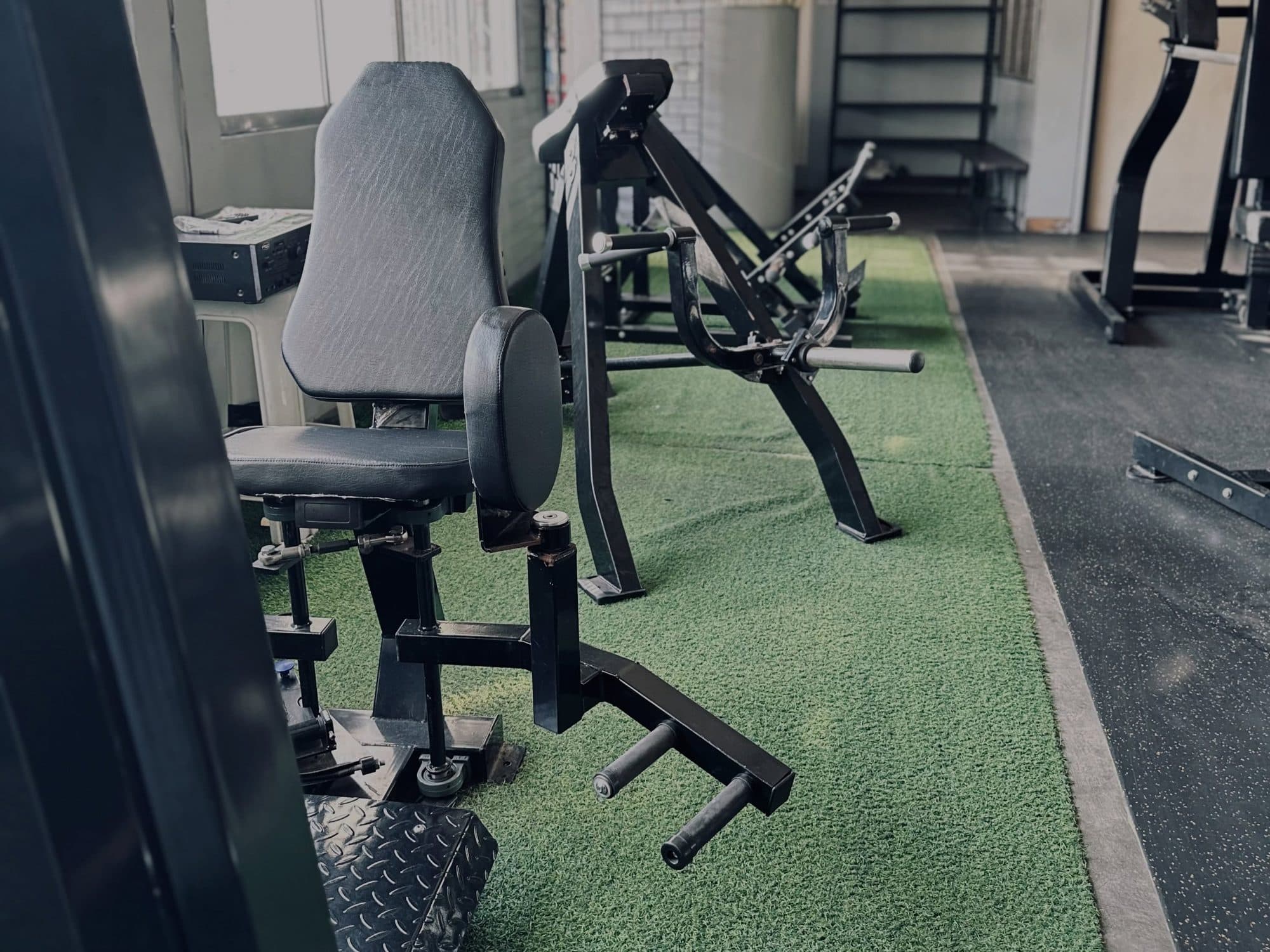 A row of squat racks reflected in the wall mirrors