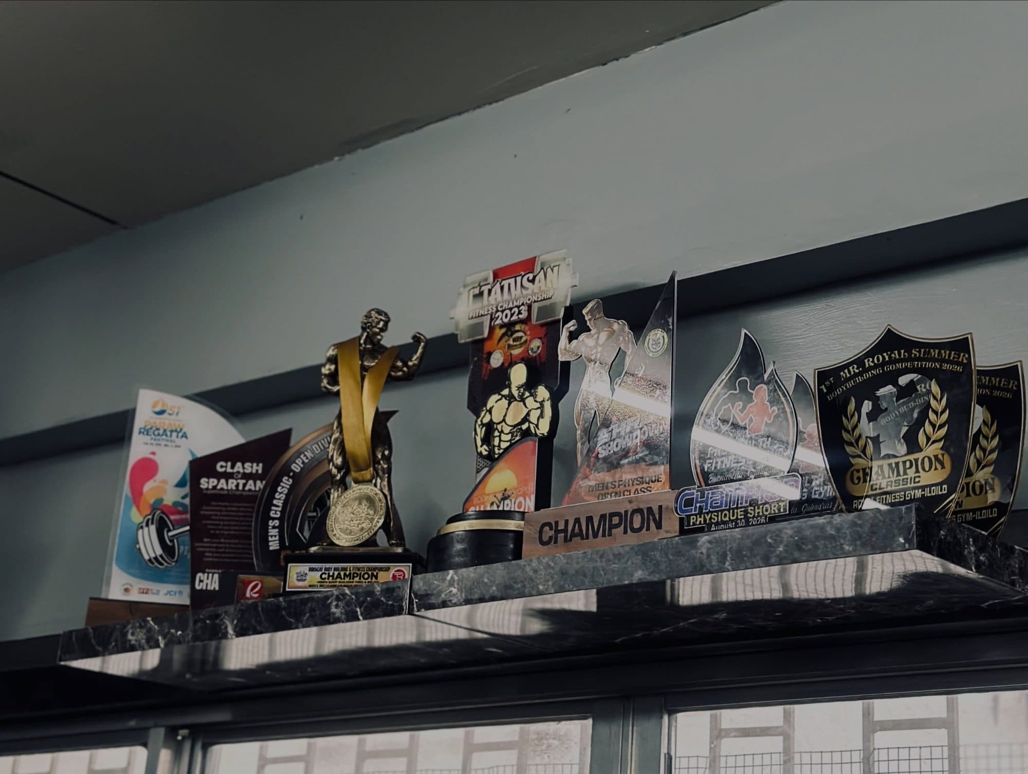 A shelf of championship trophies and plaques won by Project-E athletes