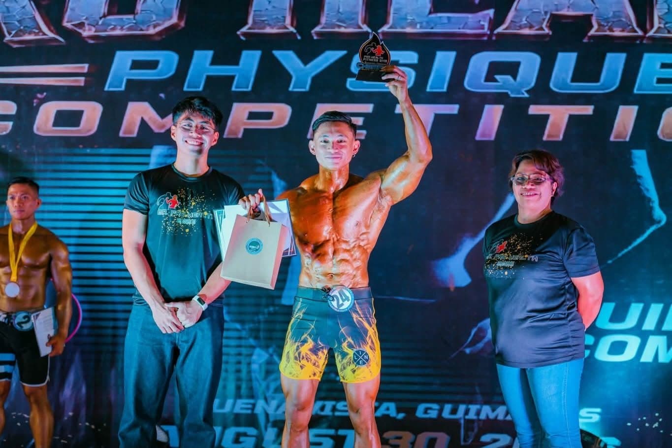A Project-E athlete flexing on stage at the Pro Health Physique Competition